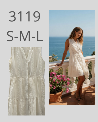Vestido blanco sin mangas, con modelo sonriendo frente al mar y flores.