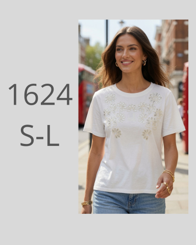 Mujer sonriente con camiseta blanca y jeans, caminando por la calle.