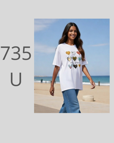 Mujer caminando en la playa con camiseta blanca y jeans, sonriendo.