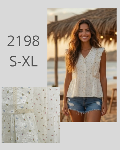 Mujer con blusa clara y short, sonriendo frente a un fondo playero al atardecer.
