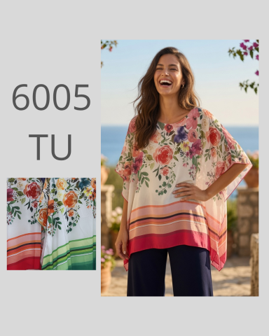 Mujer sonriente con blusa estampada de flores y pantalones oscuros, fondo natural.