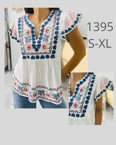 Blusa blanca con diseño floral y bordado en tonos azules y rosas. Tallas S-XL.