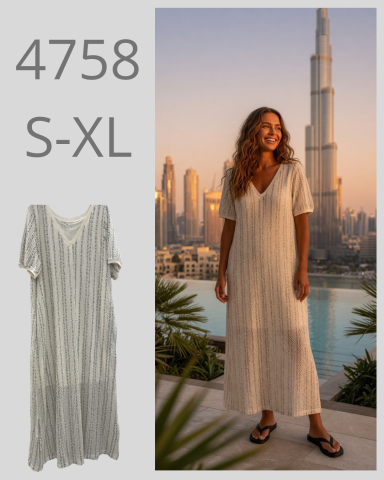 Mujer con vestido largo y sandalias, de pie frente a un paisaje urbano moderno.