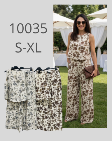Mujer con un conjunto de blusa y pantalones florales en un evento al aire libre.