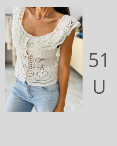 Mujer con blusa blanca de encaje y jeans claros, mostrando un estilo casual.