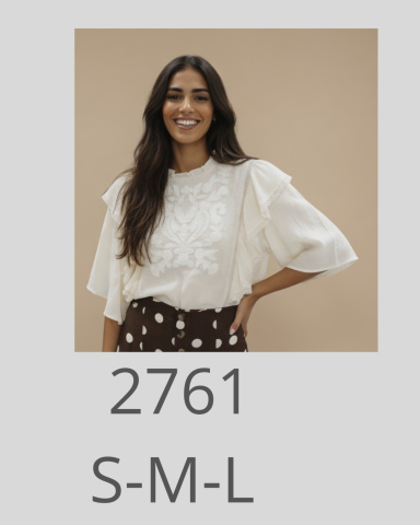 Mujer sonriente con blusa blanca y falda con lunares sobre fondo beige.