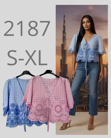 Blusa de rayas en azul y rosa con bordado, combinada con jeans, fondo de ciudad moderna.