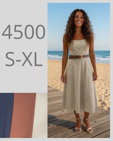 Mujer con vestido beige en la playa, sonriendo, con cinturón y fondo de mar.