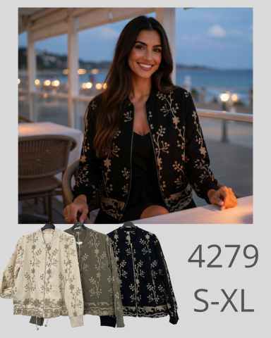 Mujer sonriente con chaqueta bordada en un entorno al atardecer junto al mar.