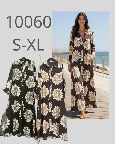 Mujer con vestido largo estampado en tonos marrones y negros, en una pasarela junto al mar.