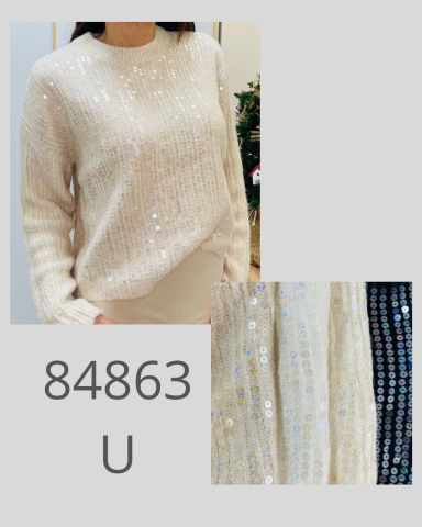 Mujer con suéter claro con lentejuelas brillantes y fondo negro.