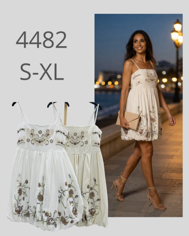 Vestido blanco con bordados florales, modelo S-XL, lucido por una mujer en un entorno nocturno.