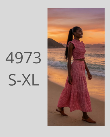 Mujer caminando por la playa al atardecer, vestida con un vestido largo rosa.