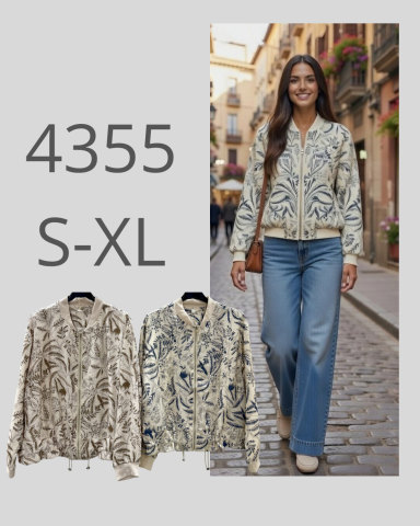 Mujer sonriente con chaqueta de diseño floral y jeans, caminando por una calle.