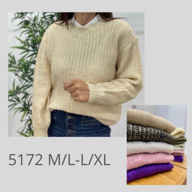 Suéter beige con textura, usado sobre una camisa blanca, junto a varios suéteres apilados.