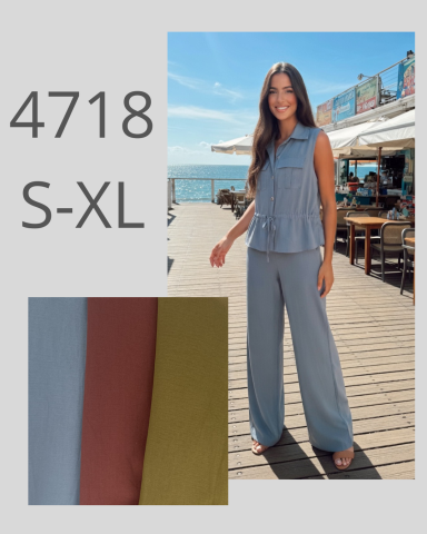 Modelo con un conjunto de pantalón y blusa en la playa, con colores pastel.