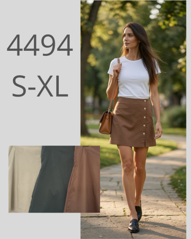 Mujer caminando con blusa blanca y falda marrón con botones. Fondo natural y urbano.