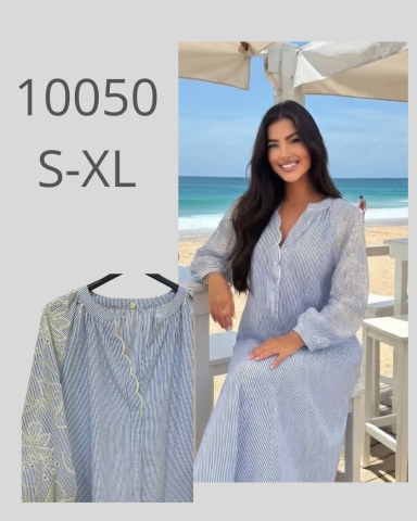 Modelo sonriente con vestido azul claro en la playa. Tallas S-XL disponible.