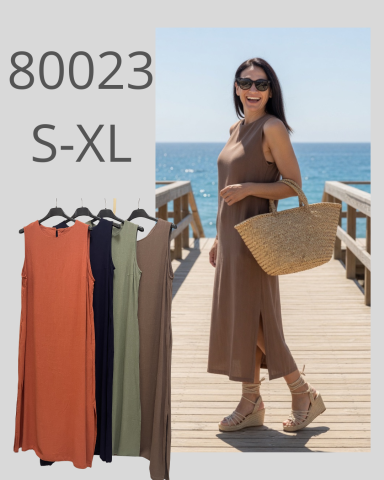 Mujer sonriendo con vestido largo, sandalias y bolso, frente al mar. Estilo veraniego.