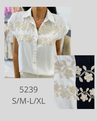 Camisa blanca con bordados florales beis en el pecho, disponible en tallas S/M y L/XL.