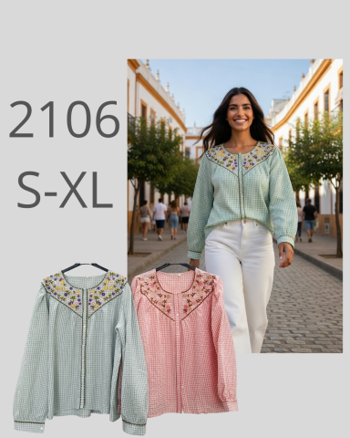 Mujer caminando por una calle con árboles, usando blusa decorada. Disponibles tallas S-XL.