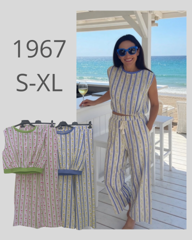 Mujer vestida con un conjunto de rayas, posando junto al mar. Estilo relajado y veraniego.