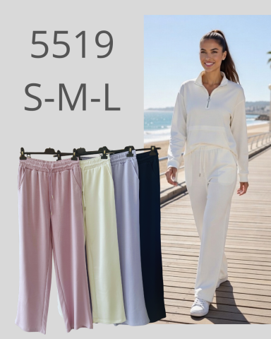 Mujer caminando por un muelle, con pantalones en colores pastel colgados a un lado.