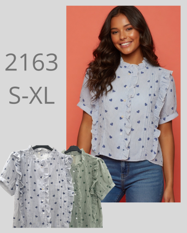 Mujer sonriendo, lleva una camisa de botones con estampado, fondos en gris y verde.
