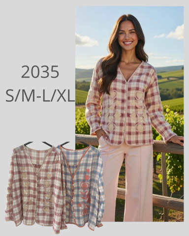 Mujer sonriente con blusa de cuadros frente a un paisaje de viñedos.