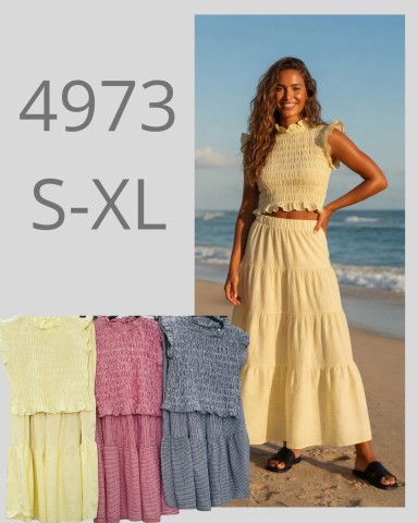 Mujer sonriente con vestido amarillo en la playa, muestra opciones de talla S-XL.