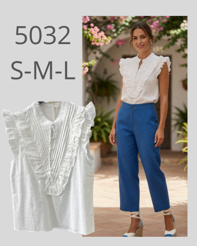 Blusa blanca con volantes y pantalones azul claro. Modelo sonriente en un entorno decorativo.