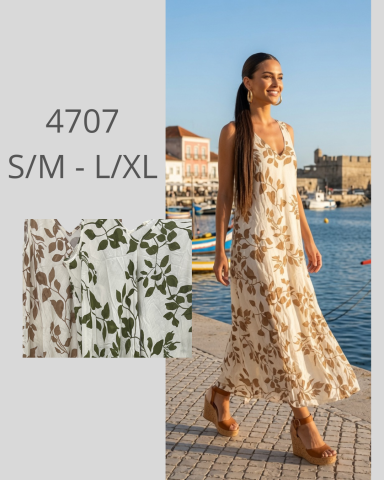 Mujer sonriente con vestido largo de flores, caminando junto al mar al atardecer.
