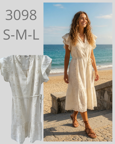 Mujer sonriente con vestido claro, caminando en la playa junto al mar.