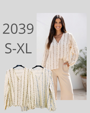 Mujer sonriente con blusa clara de estampado en un entorno luminoso y elegante.