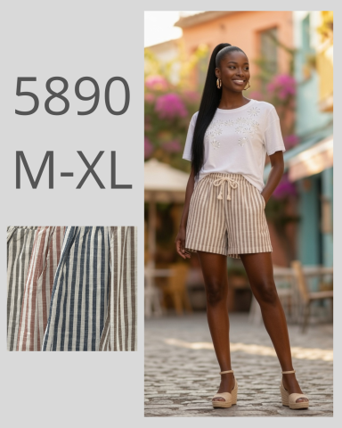 Mujer de pie con pantalones cortos beige y camiseta blanca en un entorno colorido.