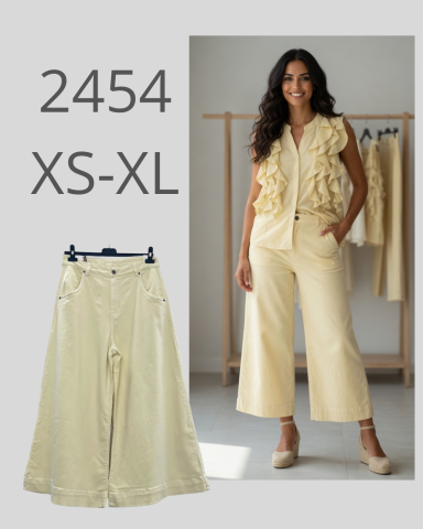 Mujer en conjunto amarillo claro con blusa rizada y pantalones anchos.