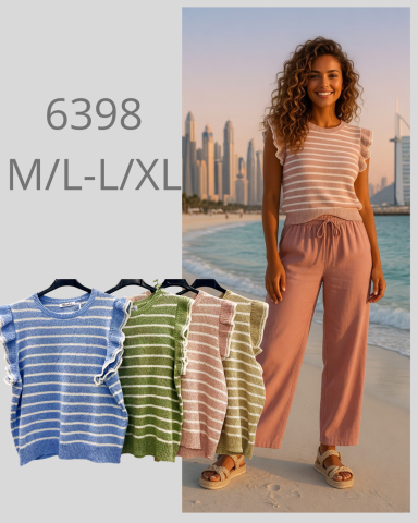 Mujer sonriente en la playa, luciendo un conjunto de camiseta y pantalón. Colores variados.
