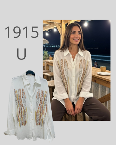 Mujer sonriente con blusa blanca decorada, sentada en un restaurante iluminado.