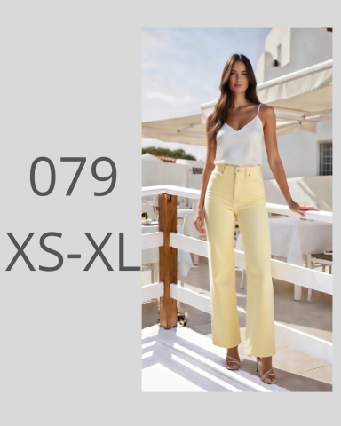 Mujer con blusa blanca y pantalones amarillos, posando en un entorno al aire libre.