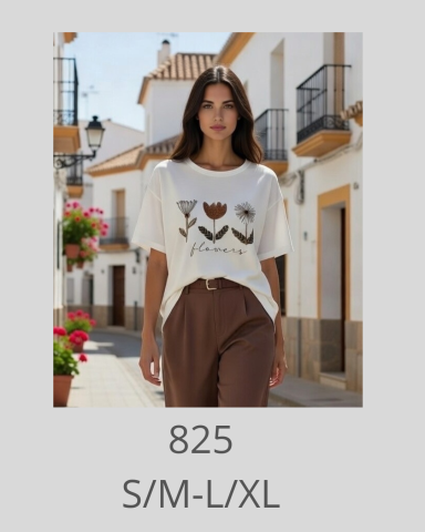 Mujer con camiseta blanca y pantalones marrones en una calle con casas blancas.