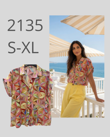 Camisa colorida con estampado abstracto, combinada con pantalones amarillos en un entorno costero.
