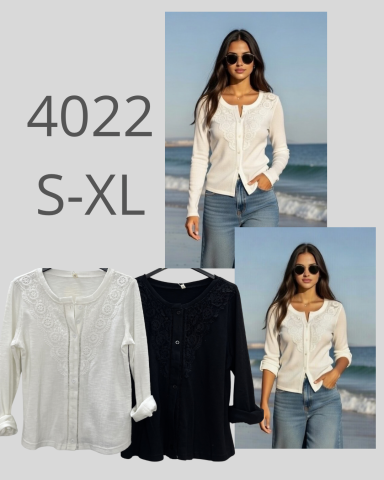 Modelo con blusa blanca y negra, de fondo playero, mostrando tallas S-XL.