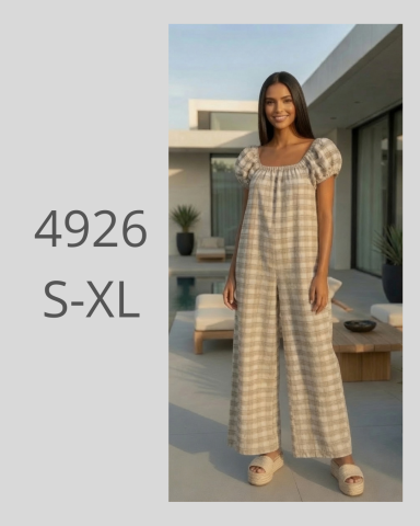 Mujer de pie con un mono de cuadros, fondo de patio moderno. Tallas S-XL.