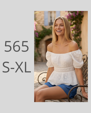 Mujer sonriente con blusa blanca y pantalones cortos azules, sentada en un banco.