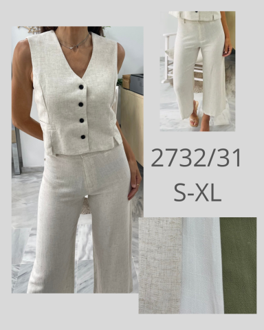 Mujer con top claro de botones y pantalones blancos en un entorno moderno.