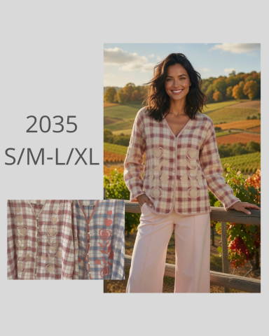 Mujer sonriente con camisa de cuadros en un paisaje de campo otoñal.
