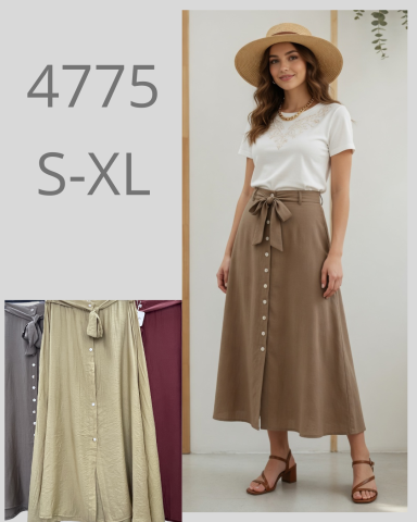 Mujer con sombrero y blusa blanca, luciendo una falda larga con botones. Disponibilidad S-XL.