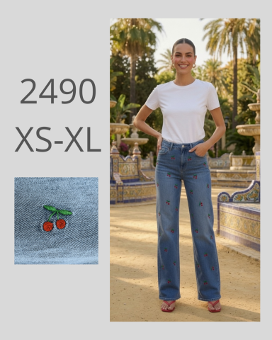 Mujer sonriente con camiseta blanca y jeans de corte amplio, en un entorno al aire libre.
