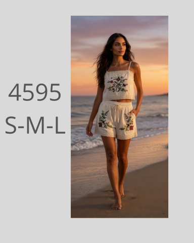 Mujer caminando por la playa al atardecer, con un conjunto blanco de top y pantalones cortos.