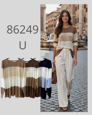 Mujer sonriente luciendo un conjunto de ropa en tonos marrones y blancos en un entorno urbano.